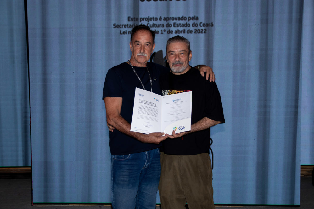 Armando Abreu, presidente da Qair Brasil, entrega a Claudio Silveira, idealizador do Dragão Fashion Brasil, o certificado que reconhece a compensação das emissões energéticas associadas ao DFB Festival 2026.